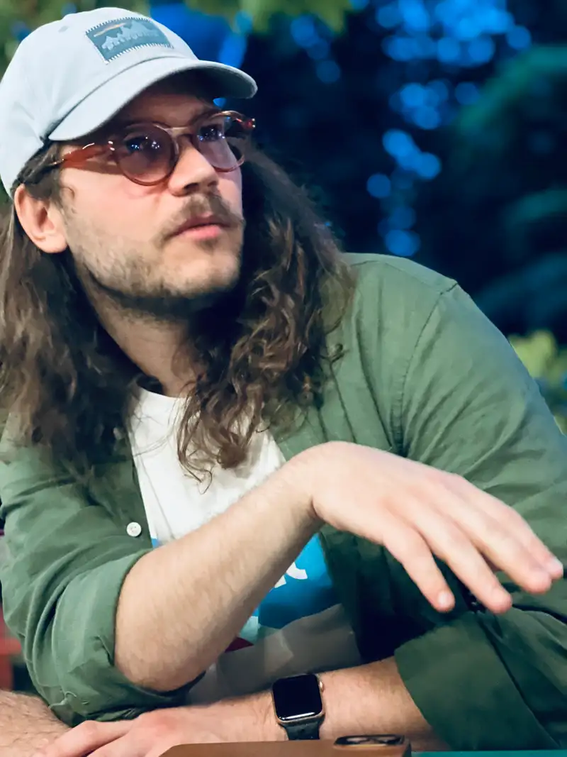 On this image Gergely is at a pizza venue near lake Balaton. Based on his pose, he is about to explain something very enthusiastically while looking into the distance.